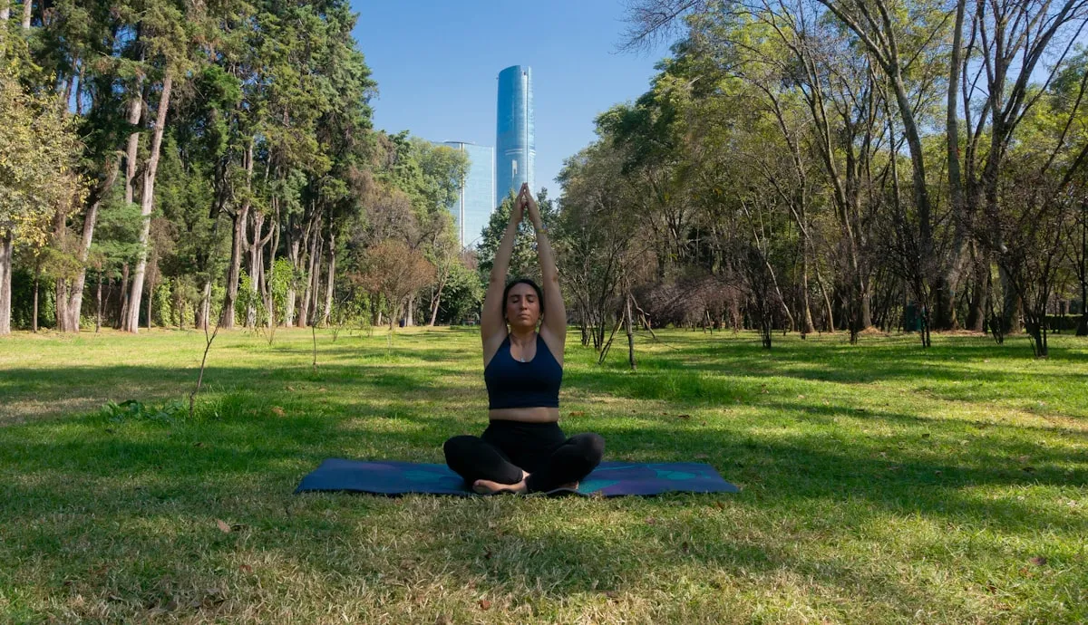 Woman practicing yoga on a mat in a peaceful park setting