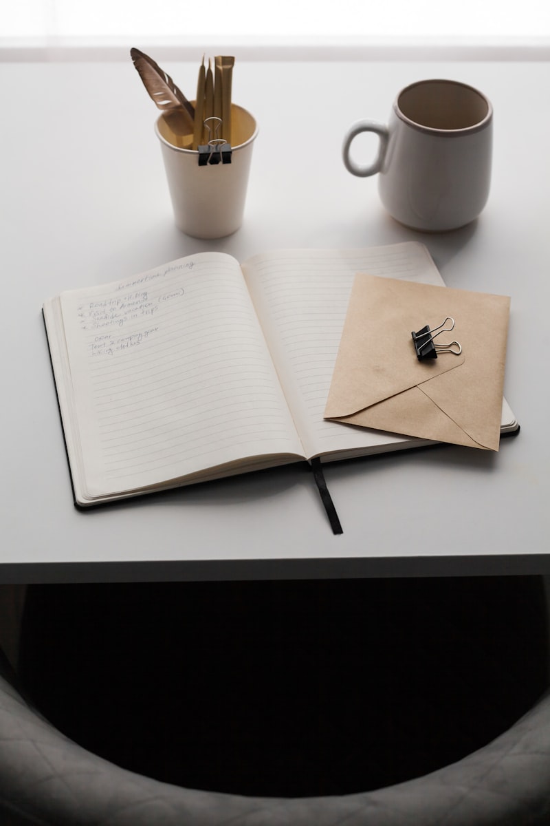 Open notebook next to a cup of coffee on a cozy table
