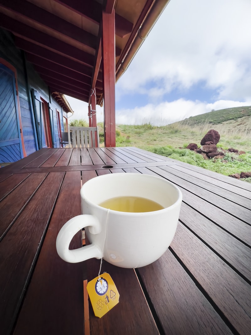 A cup of tea sitting on a wooden deck in soft morning light